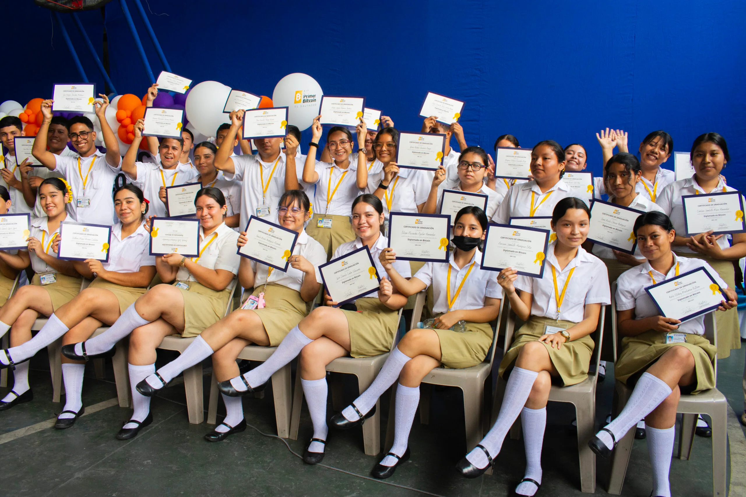 Students in El Salvador holding up their My First Bitcoin graduation certificates