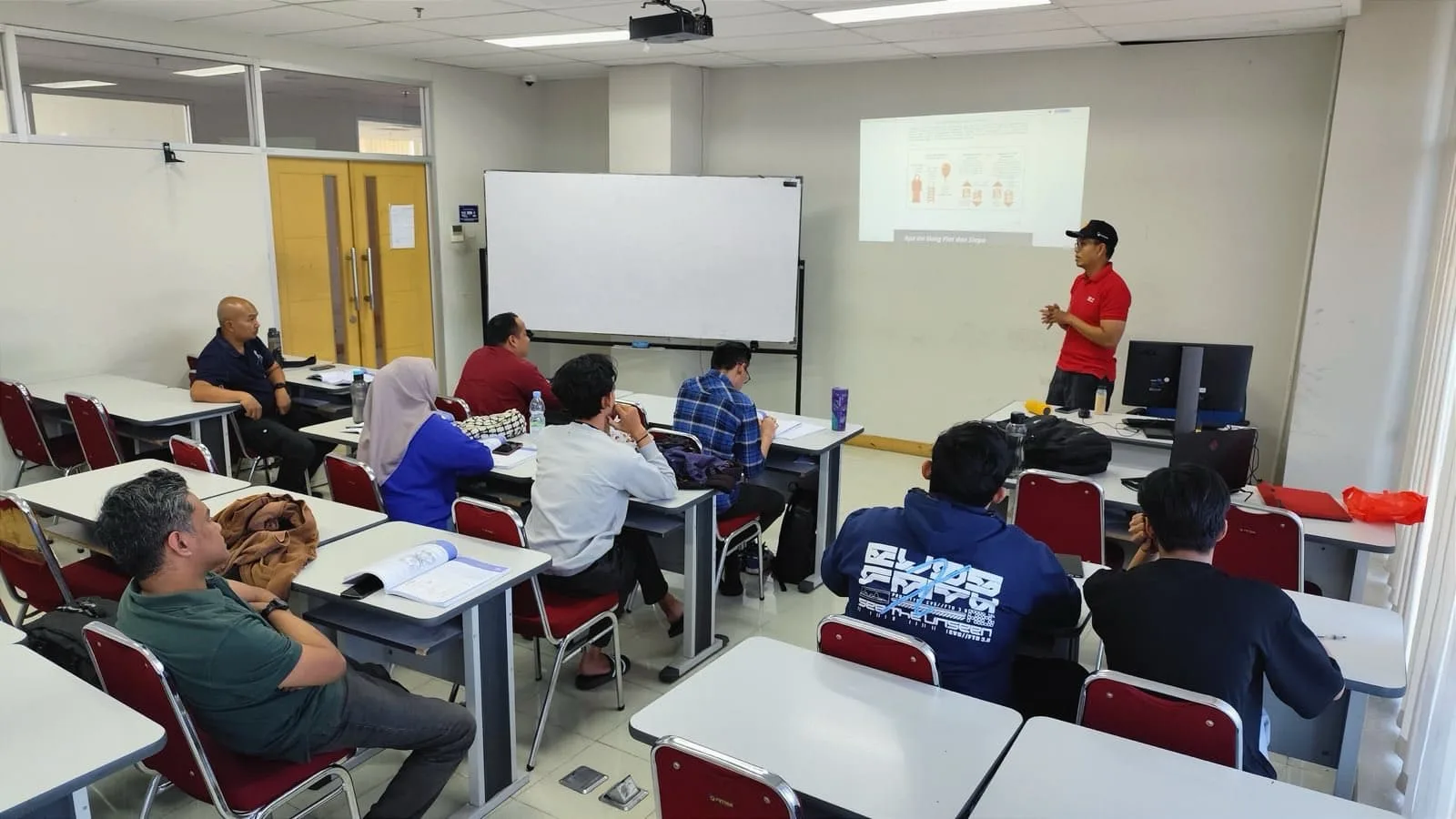 Instructor teaching a My First Bitcoin classroom session, students seated at desks