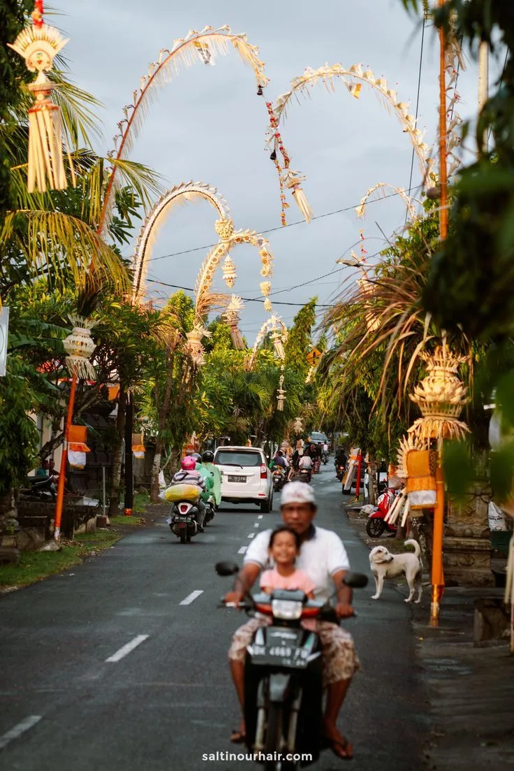 A street in Bali decorated with traditional penjor bamboo poles for a religious ceremony